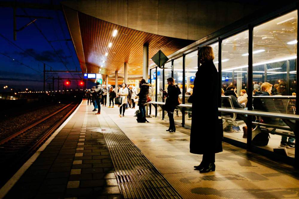 Train Station At Night With Many People Waiting For Trains