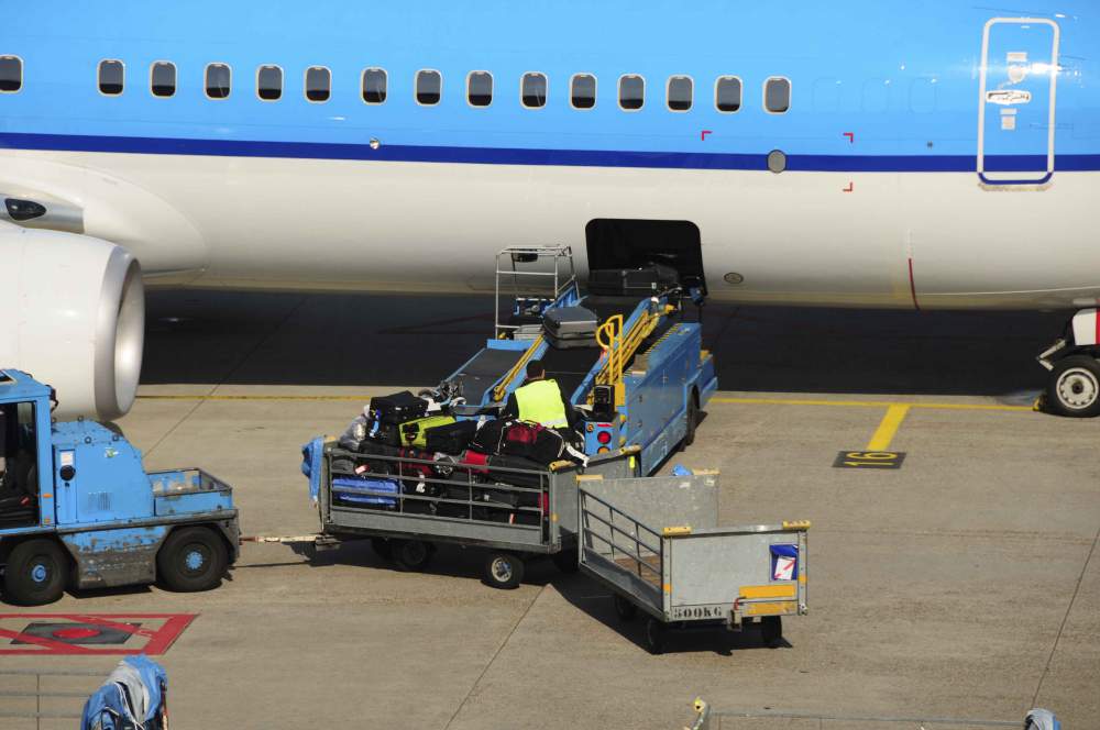 Airport Workers Loading Baggage And Luggage Onto A Large Aeroplane