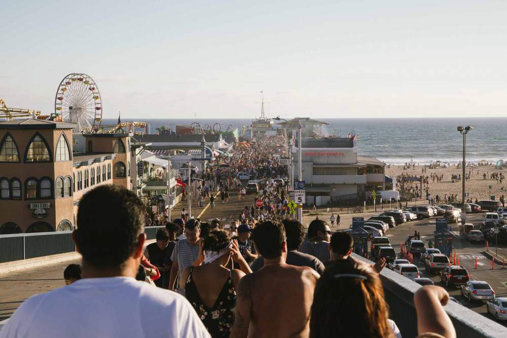 Crowds Of People Going To Amusement Park Near Seaside