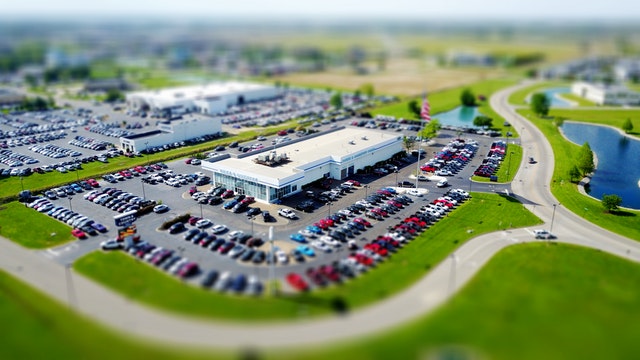 Ariel view of large car dealership with a car showroom