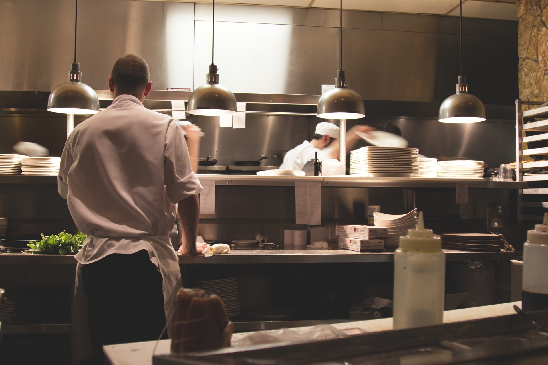 Chefs And Cooks Working In Kitchen Area Of Restaurant